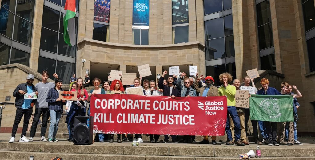 demonstrators on Buchanan steps with banner reading 'corporate courts kill climate justice'